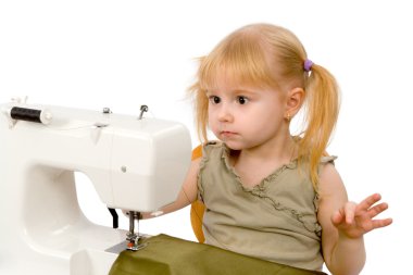 The little girl and a sewing machine clipart