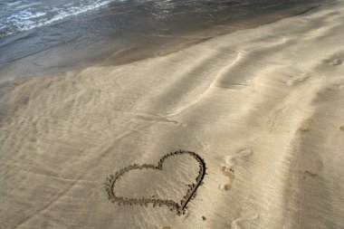 Heart on sand on ocean beach clipart