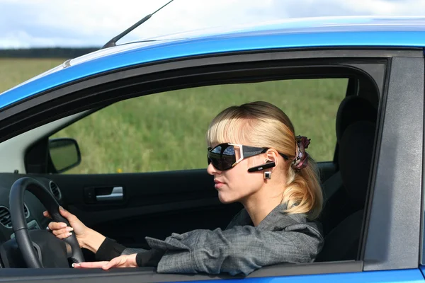 Młoda Blond Kobieta Niebieskim Samochodem Okulary Przeciwsłoneczne Rąk Wolny Bluetooth — Zdjęcie stockowe