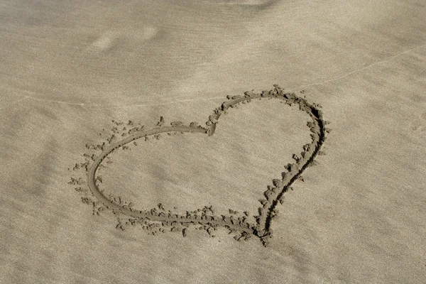 Corazón en la arena en la playa del océano —  Fotos de Stock