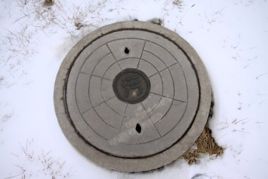 Sewage manhole covers in the snow clipart