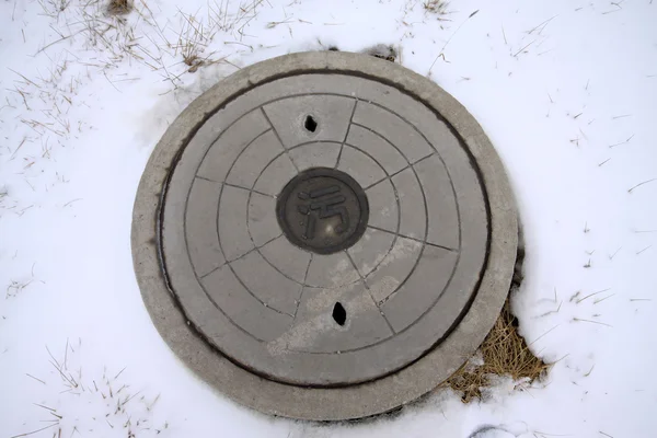 Sewage manhole covers in the snow — Stock Photo, Image