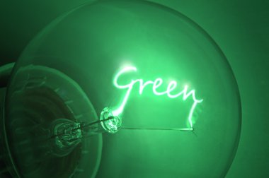 Close up of green light bulb with the illuminated filament spelling the word 'Green' clipart