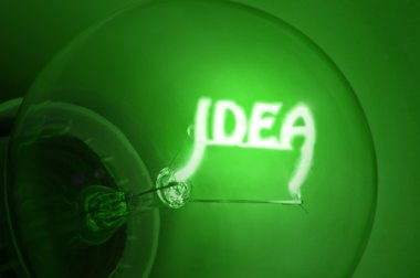 Close up of green illuminated light bulb filament spelling the word 