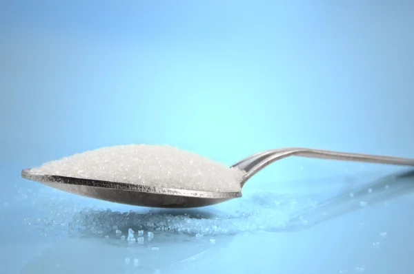Kapatın Düşük Düzeyde Yakalanıyor Bir Çay Kaşığı Şeker Granülleri Mavi — Stok fotoğraf