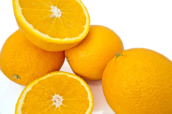 Закрыть Захватив Несколько Свежих Цельных Срезать Апельсины Над Белым — стоковое фото