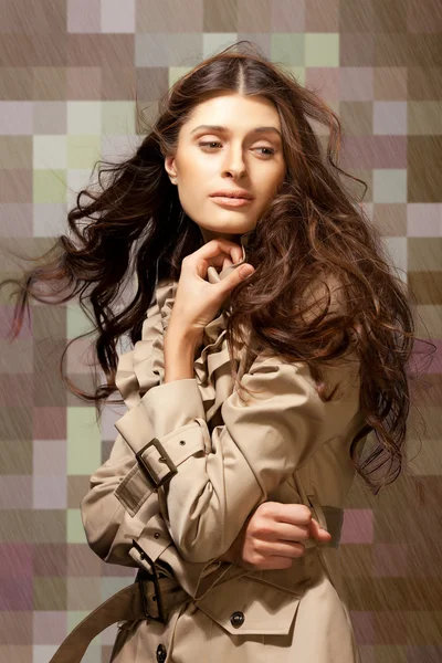 抽象的な市松模様の背景に縮れた髪の長い若いエレガントな女性 — ストック写真