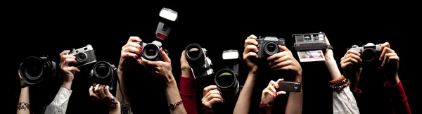 Verhoogde handen met photocameras — Stockfoto