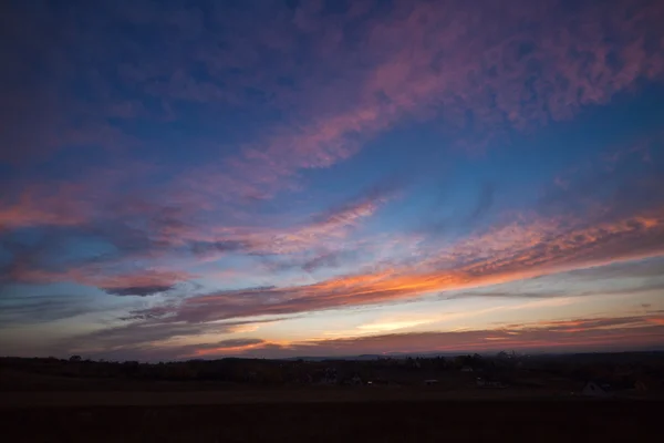 stock image Sun below horizon creates colorful lights on clouds - from orange to pink and violet