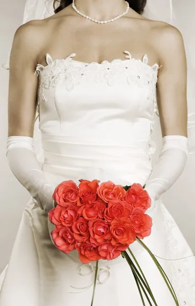 Mulher de vestido de noiva com um monte de rosas — Fotografia de Stock