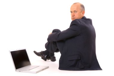 Serious businessman sitting on the floor clipart