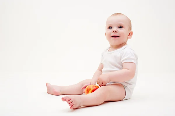 Baby with apple sitting on the floor — Stock Photo, Image