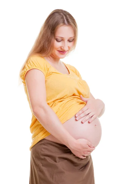 Беременная женщина смотрит на свой живот — стоковое фото