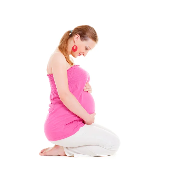 Smiley gravid kvinna sitter på golvet — Stockfoto