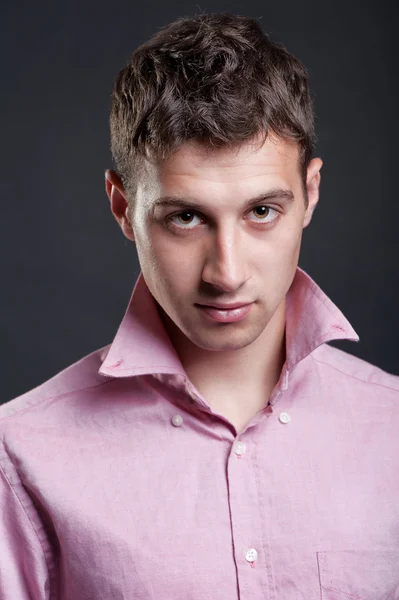 Portret van een jonge man in roze shirt — Stockfoto