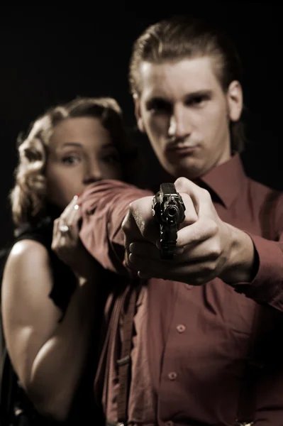 Woman hiding behind the man with gun — Stock Photo, Image