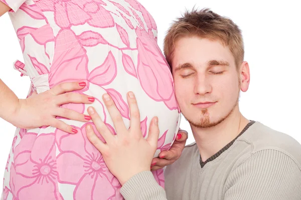 Молодой человек слушает своего нерожденного ребенка — стоковое фото