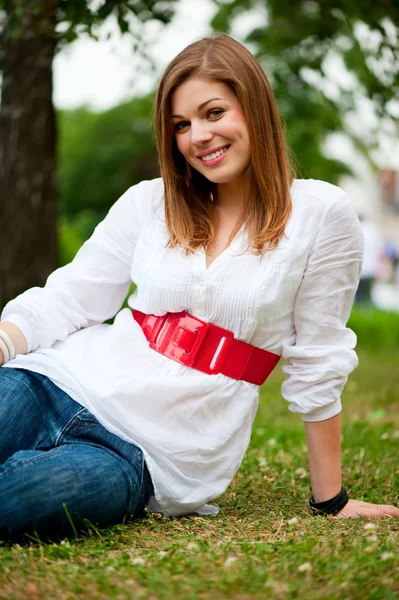 Attractive woman sitting on the grass — Stock Photo, Image