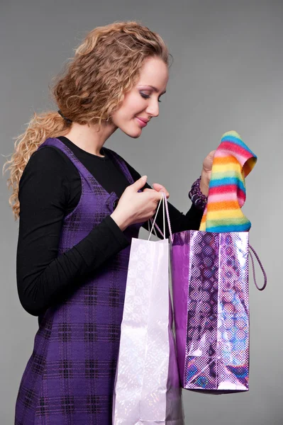 Mulher sorridente olhando para suas compras — Fotografia de Stock