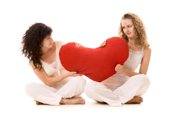 Две девушки тянут красное сердце — стоковое фото
