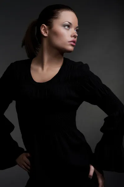 Hermosa modelo en vestido negro mirando hacia arriba —  Fotos de Stock