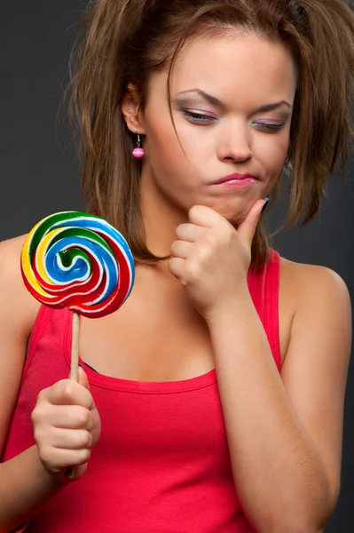 Omtänksam rolig tjej med lollipop — Stockfoto