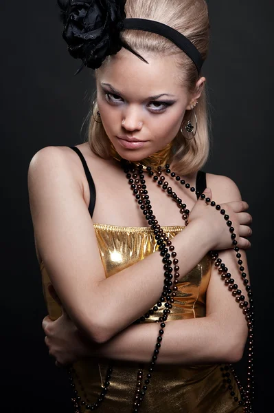 Jonge mooie vrouw in een gouden jurk — Stockfoto