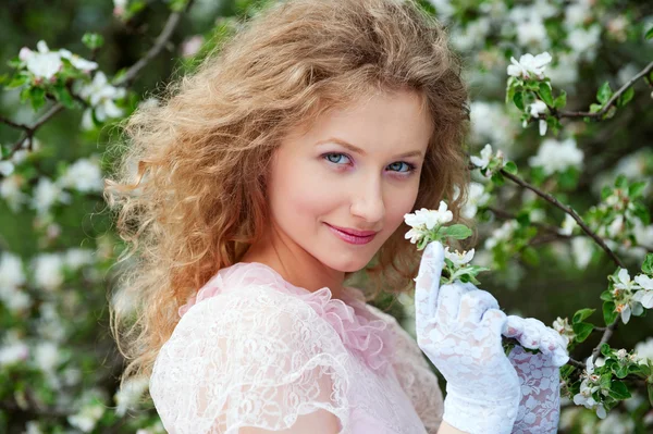 Mooie jonge vrouw in witte handschoenen met bloemen — Stockfoto