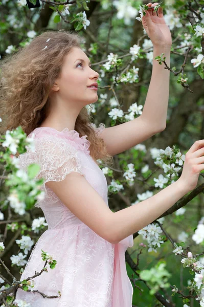 Härlig blondin i blommande orchard — Stockfoto