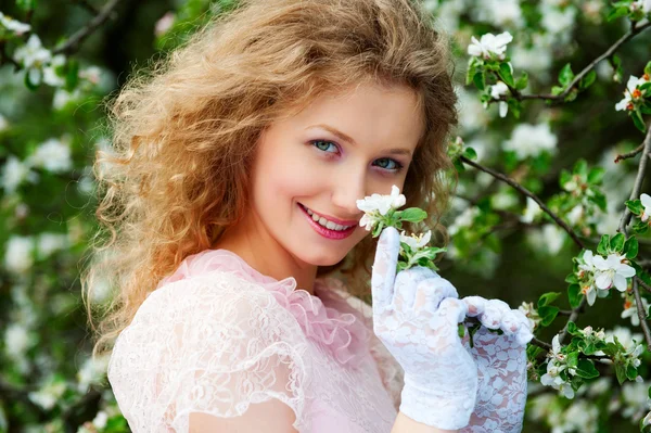 Modello sorridente in posa in fiori bianchi — Foto Stock