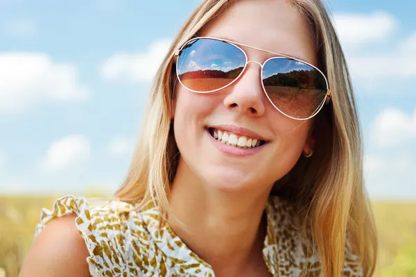 Joyeux jeune femme en lunettes de soleil — Photo