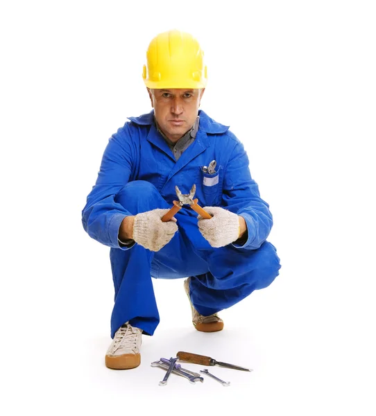 Bonito trabalhador sentado no chão com diferentes ferramentas — Fotografia de Stock