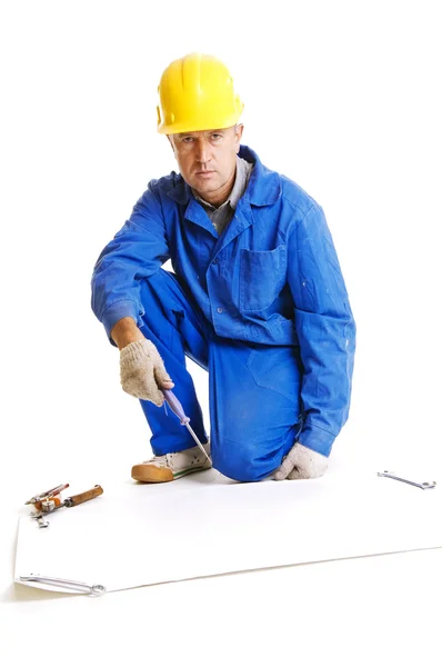 Рабочий, сидящий на полу рядом с бланковой бумагой для синих принтов — стоковое фото