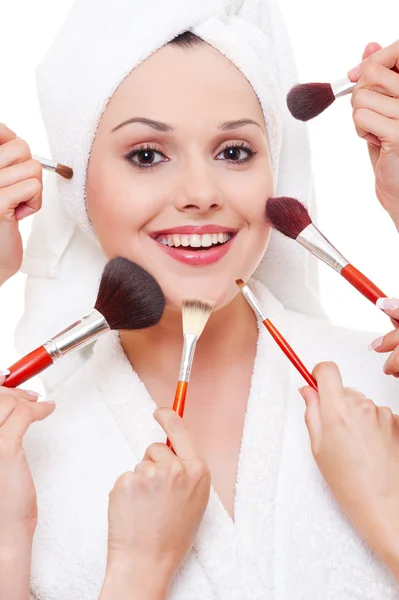 Många händer tillämpar make-up till vacker kvinna — Stockfoto