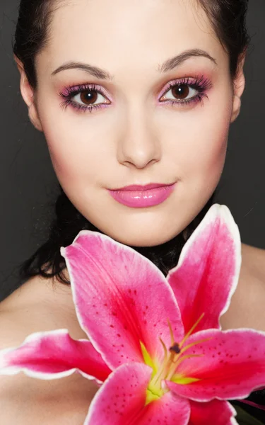 Młoda atrakcyjna kobieta z różowa lilia — Zdjęcie stockowe