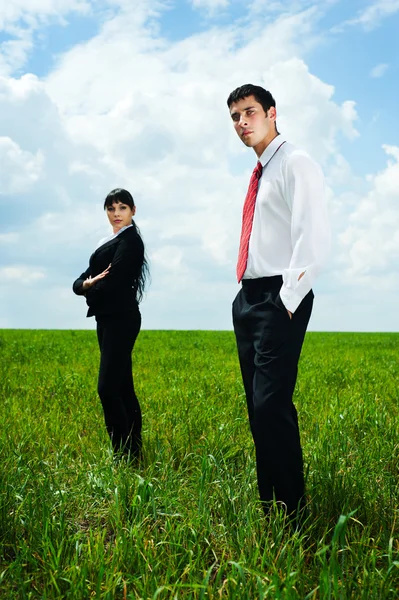 Empresários sérios em pé no prado — Fotografia de Stock