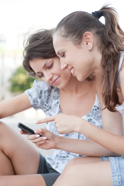 Twee vrienden kijken naar mobiel — Stockfoto