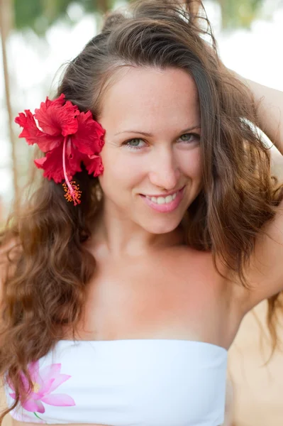 Kırmızı çiçekli çekici kadın — Stok fotoğraf