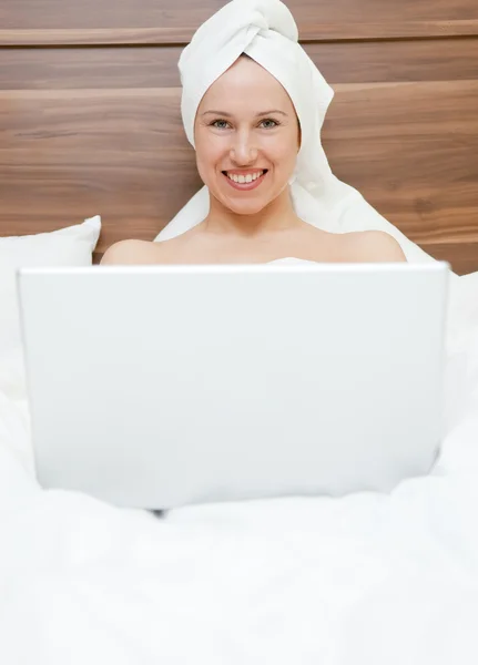 Donna attraente con computer portatile nel letto — Foto Stock