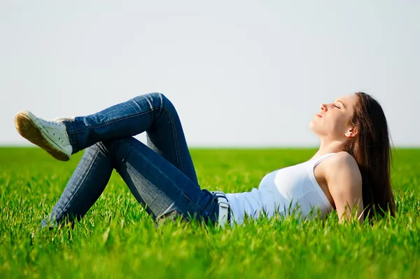 Красивая девушка лежит на траве — стоковое фото