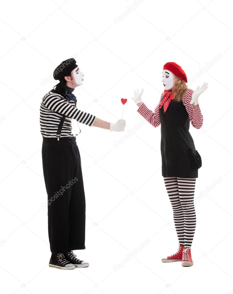 Man giving small red heart to woman