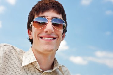 mutlu bir adam mavi gökyüzü güneş gözlüğü