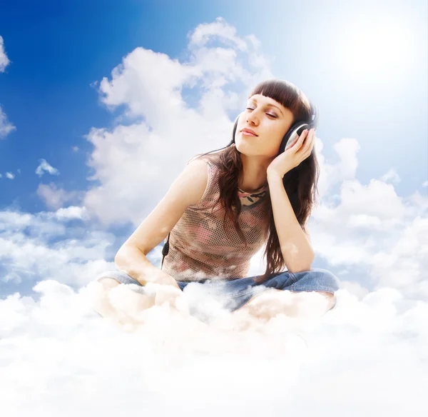 Linda adolescente ouvindo música nas nuvens — Fotografia de Stock