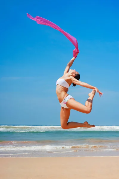 해변에서 점프 하는 아름 다운 여자 — 스톡 사진