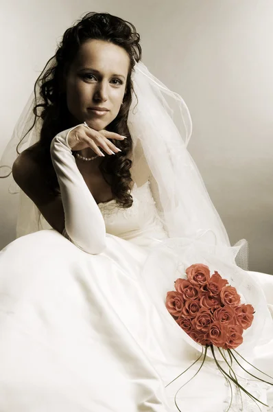 Noiva em vestido de noiva com um monte de rosas — Fotografia de Stock