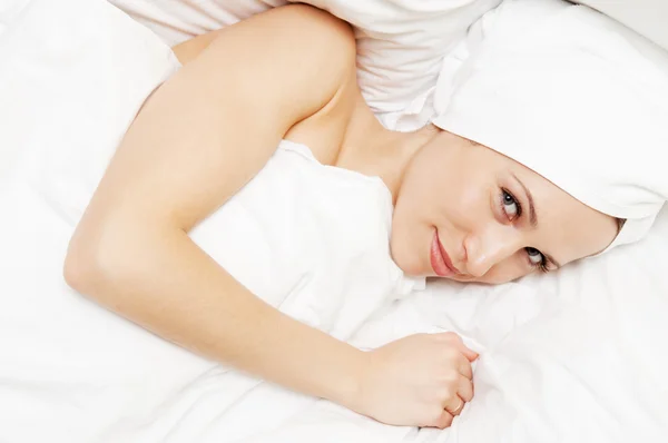 Ljusa bild av unga smiley kvinna i sängen — Stockfoto