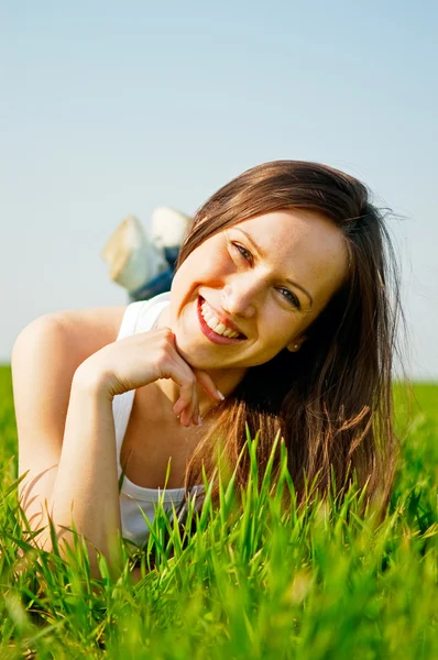 Boldog egészséges nő fekszik a fűben — Stock Fotó