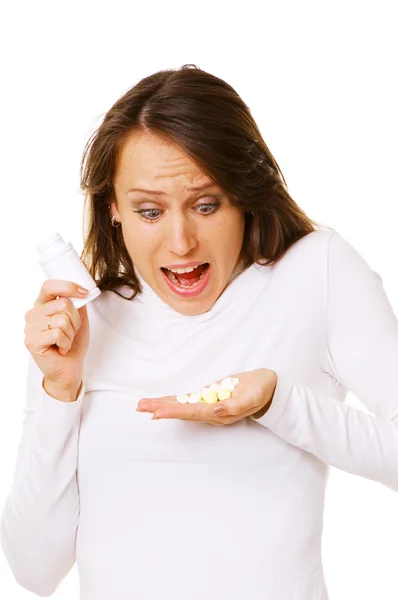Mulher chocada olhando para pílulas — Fotografia de Stock