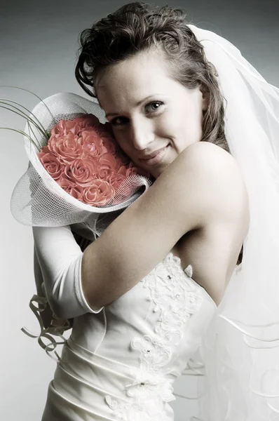 Smiley bride holding flowers — Stock Photo, Image