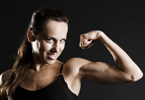 Smiley idrottskvinna visar hennes muskler — Stockfoto